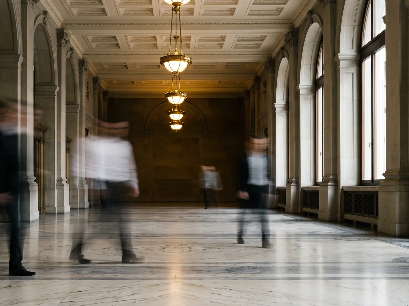 Long exposure of a marble hall with blurred passers-by