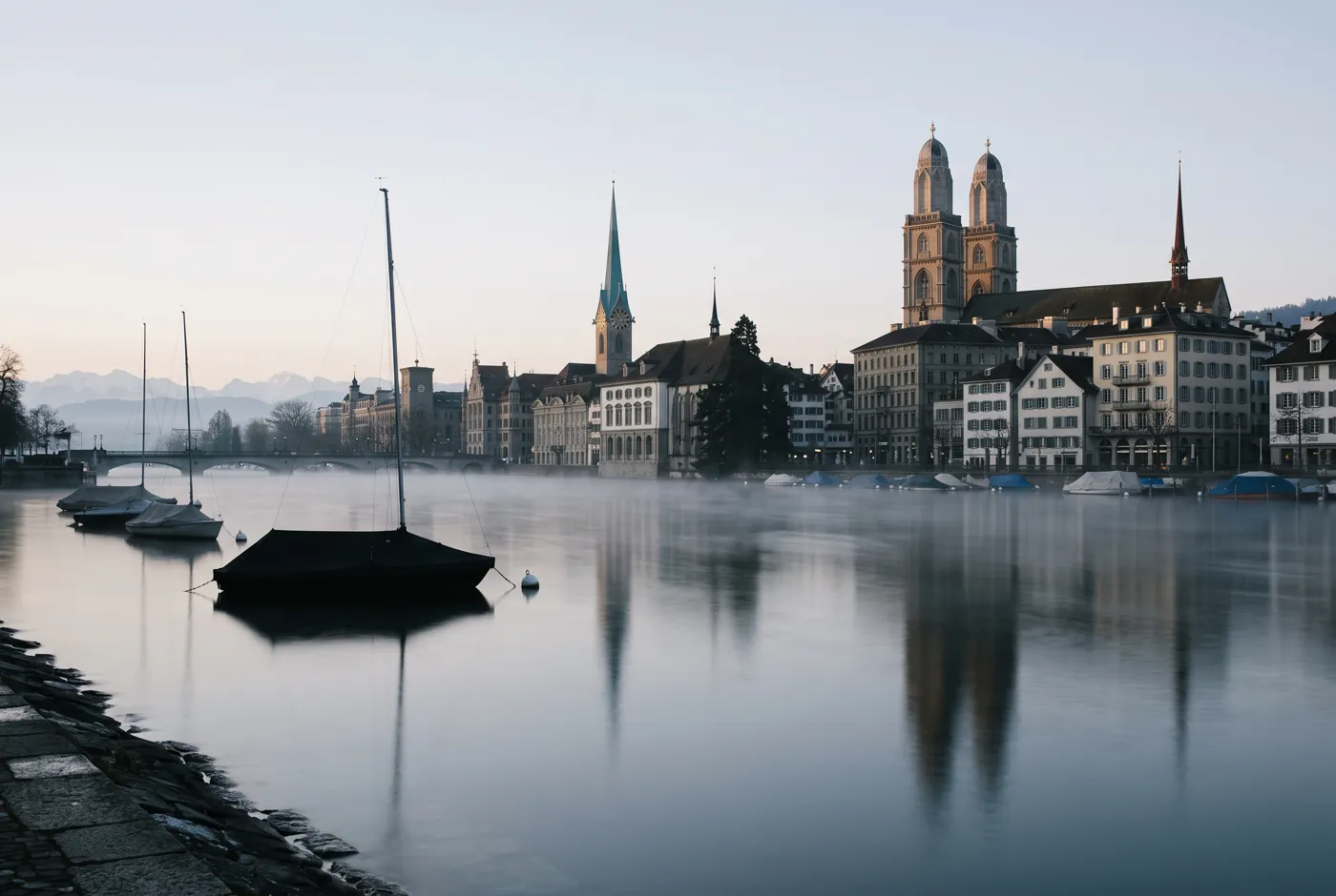 Zurich old town with the Grossmünster seen across the Limmat in morning mist